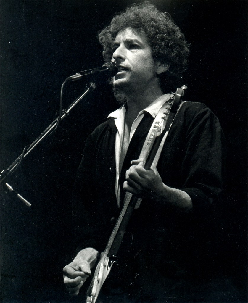 Bob Dylan sjunger och spelar gitarr på scen