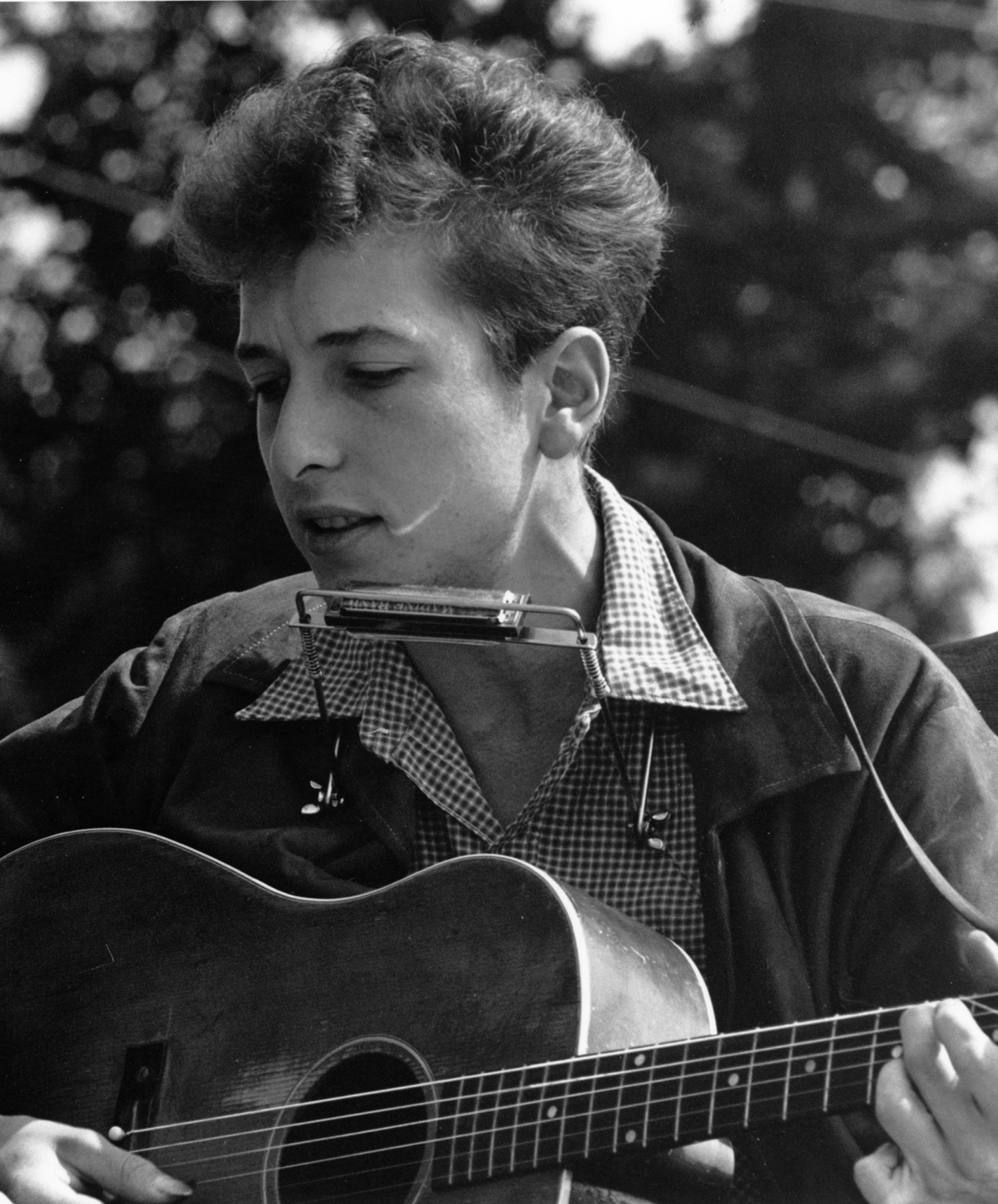 Ung Bob Dylan med gitarr och munspel